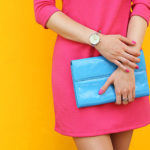 Outdoor trendy girl near yellow street wall .Stylish pink dress